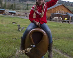 A Young Rancher has Fun Learning How to Ride A Bull
