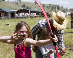 Cowboy Helping Girls To Learn Archery